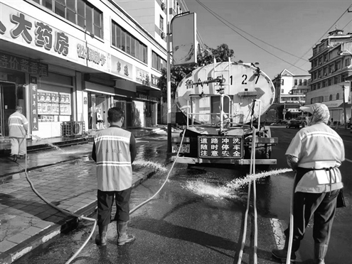 图为环卫工人在冲洗街道,迎接中秋国庆双节的到来